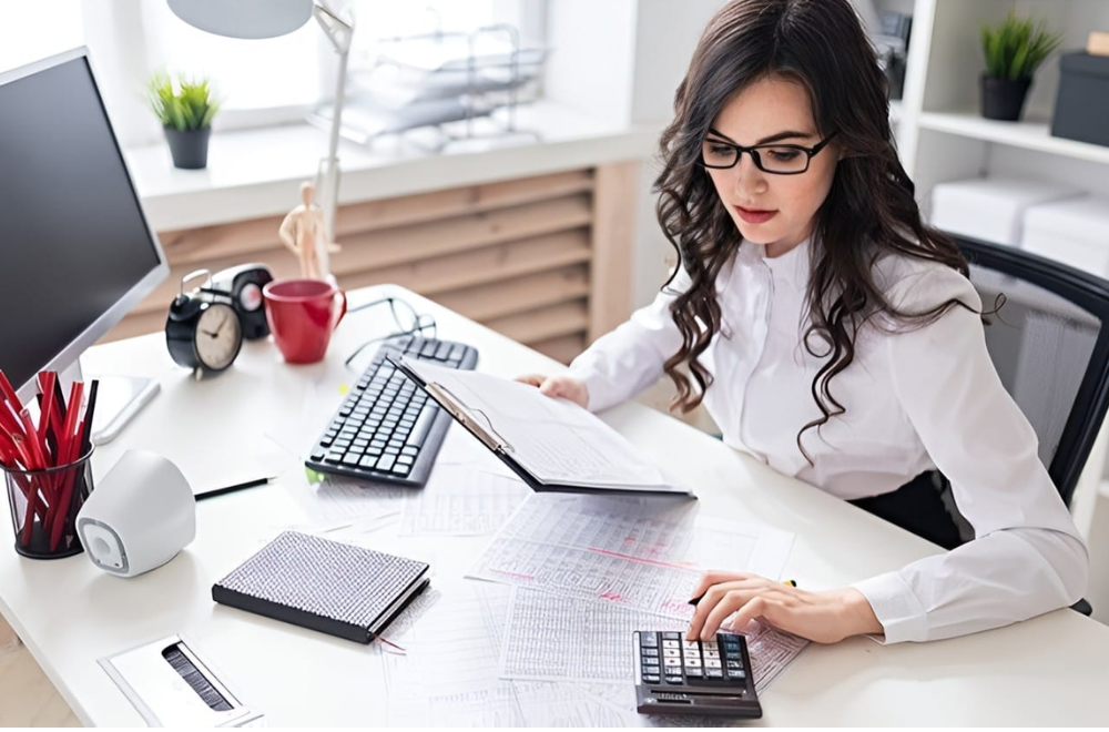 Il Valore del Tempo: Una donna concentrata al lavoro alla scrivania con un orologio e una tastiera, simbolo di gestione efficace del tempo.
