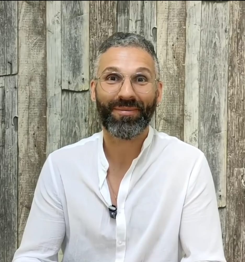 Luca, esperto di numerologia personale che sorride all'aperto, in un ambiente naturale sereno, perfetto per consulenze spirituali e numerologiche.