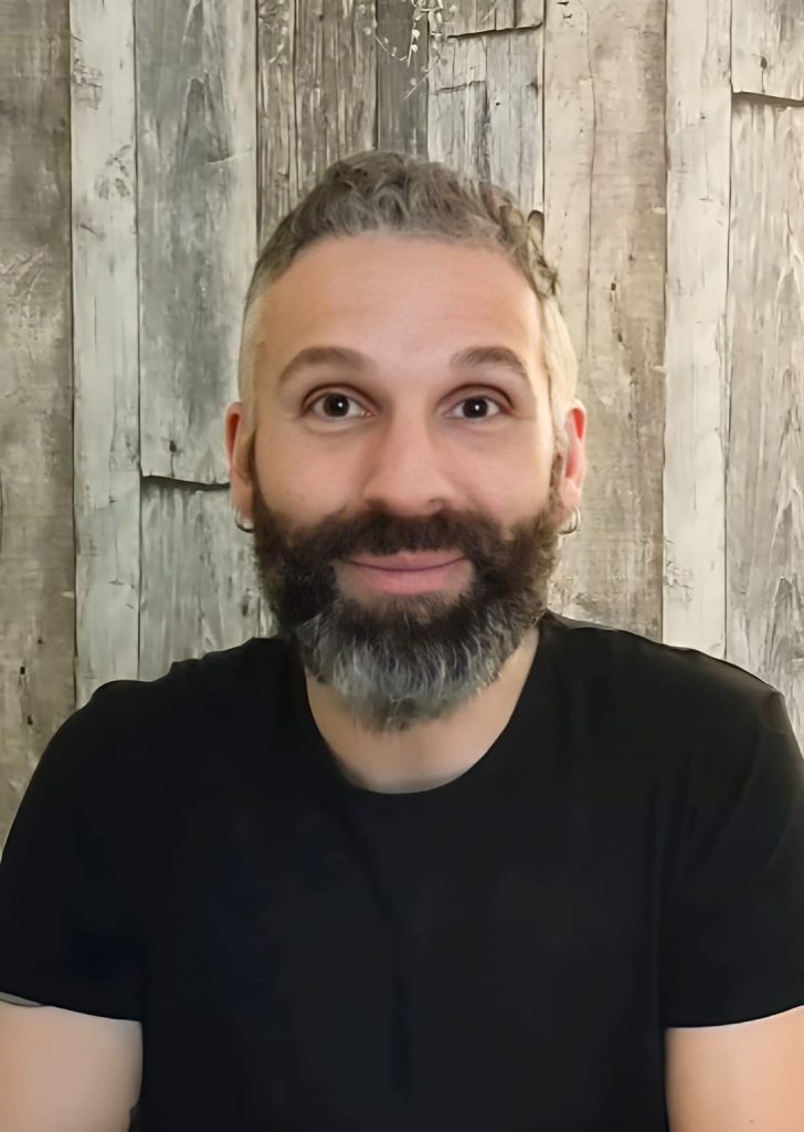 Ritratto di Luca sorridente in un ambiente caldo, simbolo di forza interiore e trasformazione personale